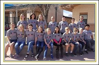 Group of students wearing Hope Squad t-shirts posing together outside