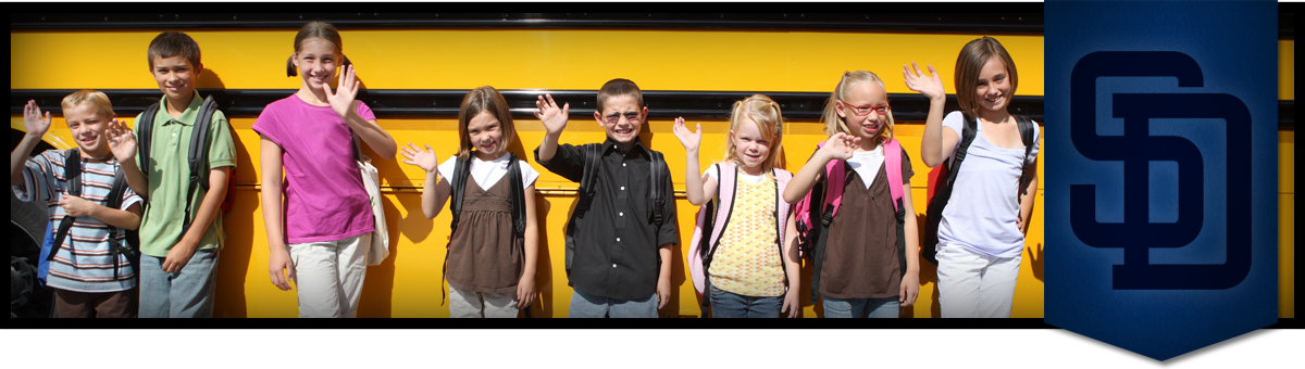 students in front of a bus waving